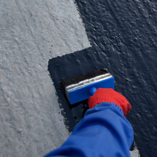 Worker applies bitumen mastic on the foundation 2